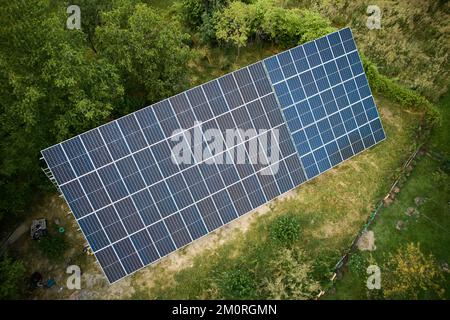 Luftaufnahme von Sonnenkollektoren im grünen Feld bei Tag. Verschiedene Arten von bodenmontierten Photovoltaiksystemen. Konzept der ökologischen Energie. Photovoltaiksammlung von Modulen als PV-Panel. Stockfoto