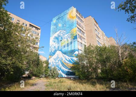 Ein riesiges gemaltes Wandgemälde am Ende eines großen Apartmentgebäudes, das eine Kombination aus Van Goghs Sternennacht und Hokusais Welle vor Kanagawa darstellt. ICH Stockfoto