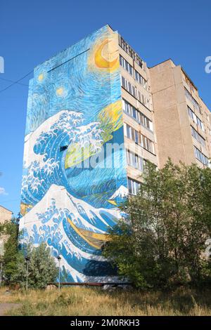 Ein riesiges gemaltes Wandgemälde am Ende eines großen Apartmentgebäudes, das eine Kombination aus Van Goghs Sternennacht und Hokusais Welle vor Kanagawa darstellt. ICH Stockfoto