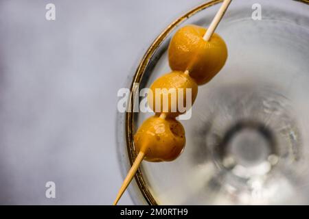Nahaufnahme von Kirschen auf einem Cocktail, der noch am Rand eines Cocktailglases liegt Stockfoto