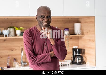 Portrait of middle age African-American man smiling at camera while standing in kitchen Stockfoto