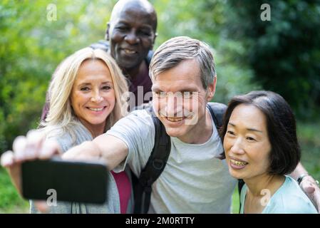 Diverse group of senior friends taking a selfie during trekking tour Stockfoto