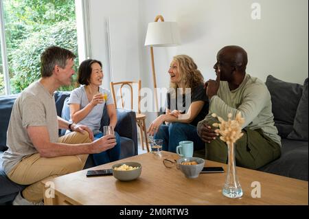 Zwei verschiedene Paare, die sich zu Hause unterhalten Stockfoto