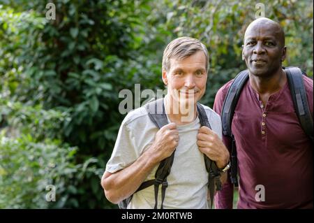 Two male friends hiking in the woods stop to take a picture Stockfoto