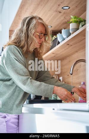 Senior woman doing dishes at kitchen Stock Photo