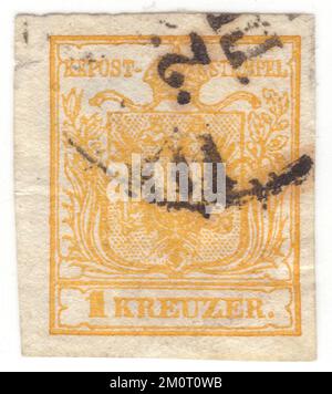 ÖSTERREICH — 1850. Juni 1: Ein gelber 1-Kreuzer-Briefstempel mit dem Wappen der österreichischen Monarchie. Die erste Ausgabe der österreichischen Monarchie (einschließlich Ungarn) Briefmarken. Die erste Briefmarkenausgabe des Reiches von Österreich war eine Reihe imperforierter, typografierter Briefmarken mit dem Wappen. Zuerst wurden sie auf grobes, handgefertigtes Papier gedruckt, aber nach 1854 wurde stattdessen glattes, maschinengefertigtes Papier verwendet. Die Briefmarken des Österreichischen Reiches wurden erstmals am 1. Juni 1850 ausgestellt: Ein Wappen unter dem Text KK Post-Stempel Stockfoto