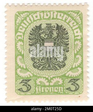 ÖSTERREICH — 1921: Ein gelb-grüner und dunkelgrüner Briefstempel mit 3 Kronen, der den Wappen der Republik Österreich darstellt, der in seiner ersten Form von der ersten österreichischen Republik ab 1919 verwendet wurde. Es besteht aus einem frei schwimmenden, einköpfigen schwarzen Adler mit goldenen Armen und einer roten Zunge, dessen Brust mit einem roten Schild bedeckt ist, das von einem silbernen Querträger gekreuzt wird. Der Adler trägt eine goldene Wandkrone mit drei sichtbaren Stiften auf dem Kopf. In seinem rechten Talon trägt er eine goldene Sichel mit der Kante nach innen, in seinem linken Talon einen goldenen Hammer Stockfoto