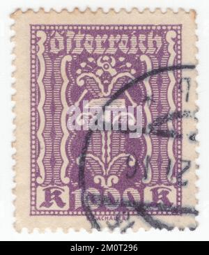 ÖSTERREICH — 1923: Eine violette Briefmarke mit 1000 Kronen, auf der Hammer und Zange als Arbeits- und Industriesymbole dargestellt sind. Die Ausgabe zeigt die Symbole Landwirtschaft, Arbeit und Industrie Stockfoto