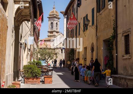 Italien, Toskana, San Quirico d'Orcia, Val d'Orcia, das zum UNESCO-Weltkulturerbe gehört, eine Straße und die Kirche Stockfoto