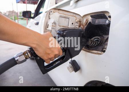 Hand mit orangefarbenem und schwarzem Ölspender Stockfoto