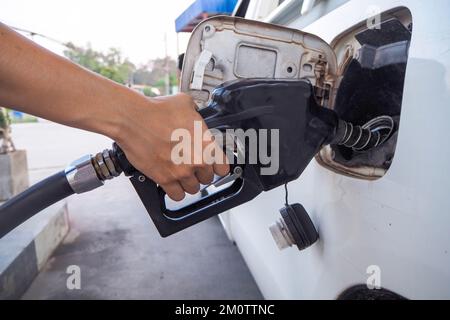 Hand mit orangefarbenem und schwarzem Ölspender Stockfoto