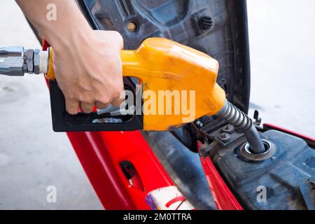 Hand mit orangefarbenem und schwarzem Ölspender Stockfoto