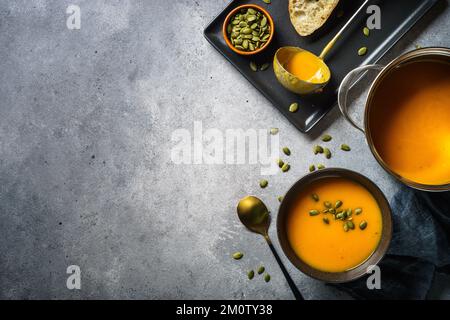 Kürbissuppe im Topf am Steintisch. Stockfoto