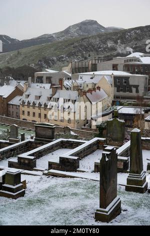 Donnerstag, 8.. Dezember 2022: Edinburgh, Schottland, Vereinigtes Königreich. Wetter. Ein kalter Witterungseinbruch im Vereinigten Königreich brachte eine leichte Schneebedeckung in die schottische Hauptstadt. Neues Grabstätte in Calton mit Arthurs Seat und Salisbury Crags in der Ferne und Dampf aus dem schottischen Parlament. Stockfoto