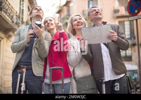 Touristen mit Koffern und Kamera spazieren durch die historischen Straßen der europäischen Stadt Stockfoto