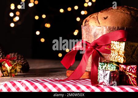 Kuchen mit Obst und Schokoladenchips auf einem Holztisch, dekoriert zu Weihnachten. Selbst gemachtes Weihnachtsbrot auf unscharfem Hintergrund, Kopierbereich. Stockfoto