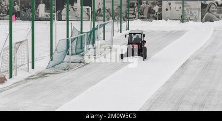 Moskau, Russland. 8. Dezember 2022. Ein Traktor reinigt Schnee von einem Fußballstadion während eines Schneefalls im Stadtzentrum. Credit: Molakaliva/Alamy Live News Stockfoto