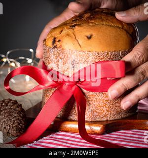 Kuchen mit Obst und Schokoladenchips auf einem Holztisch, dekoriert zu Weihnachten. Selbst gemachtes Weihnachtsbrot auf unscharfem Hintergrund, Kopierbereich. Stockfoto