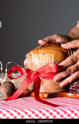 Kuchen mit Obst und Schokoladenchips auf einem Holztisch, dekoriert zu Weihnachten. Selbst gemachtes Weihnachtsbrot auf unscharfem Hintergrund, Kopierbereich. Stockfoto