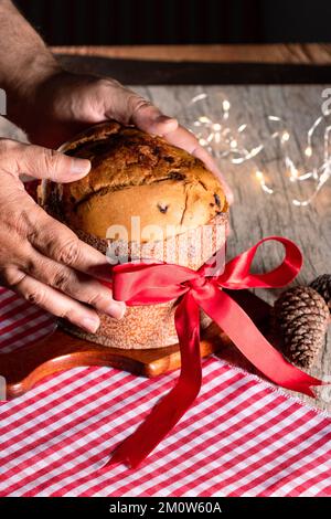 Kuchen mit Obst und Schokoladenchips auf einem Holztisch, dekoriert zu Weihnachten. Selbst gemachtes Weihnachtsbrot auf unscharfem Hintergrund, Kopierbereich. Stockfoto