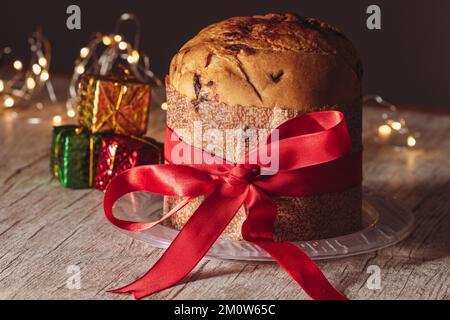 Kuchen mit Obst und Schokoladenchips auf einem Holztisch, dekoriert zu Weihnachten. Selbst gemachtes Weihnachtsbrot auf unscharfem Hintergrund, Kopierbereich. Stockfoto