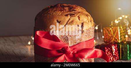 Kuchen mit Obst und Schokoladenchips auf einem Holztisch, dekoriert zu Weihnachten. Selbst gemachtes Weihnachtsbrot auf unscharfem Hintergrund, Kopierbereich. Stockfoto