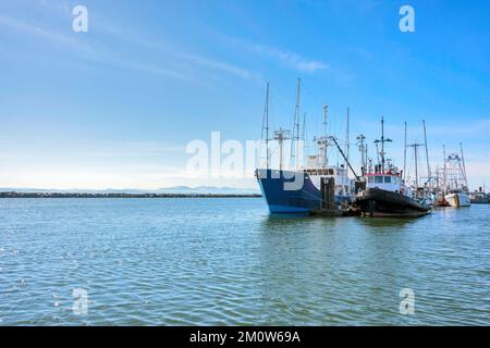 Kleiner Fischtrawler und Schlepper, die am Ozeanpier festgemacht sind Stockfoto