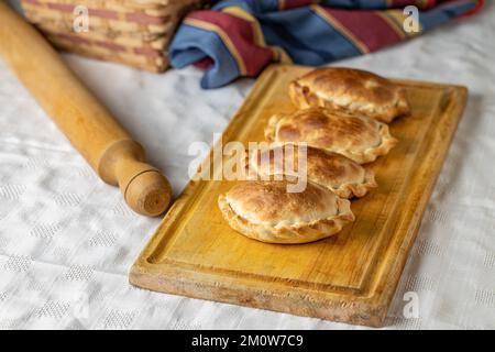 Traditionell gebackene argentinische Empanadas auf einem Brett. Speicherplatz kopieren. Stockfoto