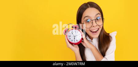 Pünktlichkeit. Letzte Chance. Pünktliches Teenager-Mädchen, das die Zeit überprüft. Erstauntes Nerd-Kind, hör dem Alarm zu. Teenager Kind mit Wecker, horizontales Poster Stockfoto