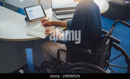 Nach Unfall und Rehabilitation kann ein behinderter Rollstuhlfahrer wieder arbeiten. Das Unternehmen, das Arbeitsplätze einstellt, die behinderte Menschen beschäftigen. Stockfoto