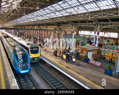 Zwei Züge an Bahnhöfen in Preston Station im Nordwesten Englands in Großbritannien. Die Architektur des Dachs ist sichtbar. Stockfoto