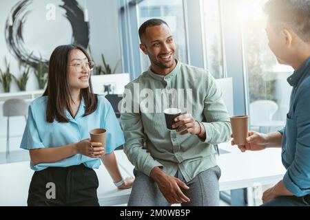 Lächelnde Gruppe multiethnischer Kollegen, die während der Pause Kaffee trinken und sich unterhalten Stockfoto