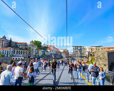 PORTO, PORTUGAL - 15. APRIL 2022: Überfüllte Brücke Dom Luis, Touristenziel, sonniger Tag, Porto, Portugal Stockfoto