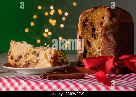 Kuchen mit Obst und Schokoladenchips auf einem Holztisch, dekoriert zu Weihnachten. Selbst gemachtes Weihnachtsbrot auf grünem Hintergrund, Kopierbereich. Stockfoto