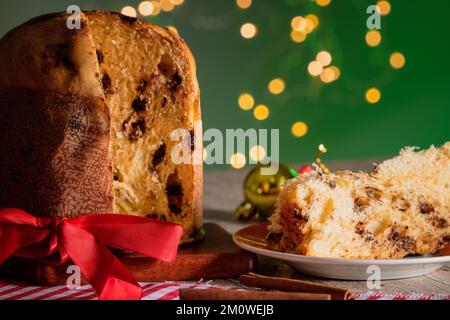 Kuchen mit Obst und Schokoladenchips auf einem Holztisch, dekoriert zu Weihnachten. Selbst gemachtes Weihnachtsbrot auf grünem Hintergrund, Kopierbereich. Stockfoto