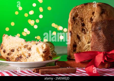 Kuchen mit Obst und Schokoladenchips auf einem Holztisch, dekoriert zu Weihnachten. Selbst gemachtes Weihnachtsbrot auf grünem Hintergrund, Kopierbereich. Stockfoto