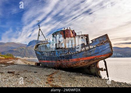 Corpach Fort William Scotland Ben Nevis und das Wrack des alten Boats von Caol, das am Kieselstrand verlassen wurde Stockfoto