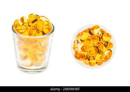 Nahaufnahme von Fischölkapseln mit Omega-3 und Vitamin D in einem Glasbecher, isoliert auf weißem Hintergrund Stockfoto