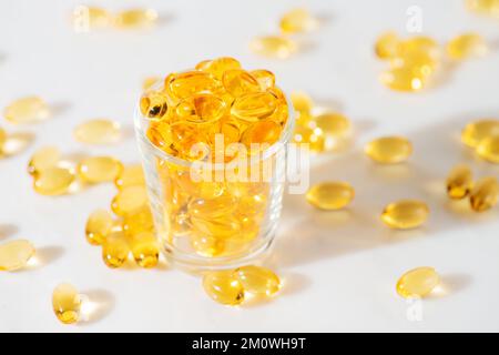 Fischöl Omega 3 Pillen Kapseln in einer Glasflasche auf weißem Marmorhintergrund, gesunde Ernährung, Nahrungsergänzungsmittel, Vitamine D. Stockfoto