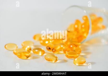 Fischöl Omega 3 Pillen Kapseln in einer Glasflasche auf weißem Marmorhintergrund, gesunde Ernährung, Nahrungsergänzungsmittel, Vitamine D. Stockfoto