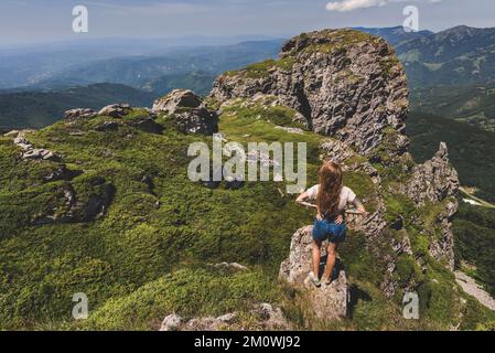 Frau Hiker steht allein auf dem Rock of Mountain Stockfoto