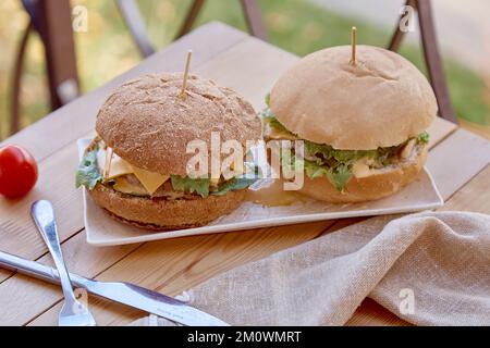 Gesunde vegetarische Kost - Burger mit Gemüseschnitzel, eingelegte Gurken und Gemüse im Freien. Stockfoto