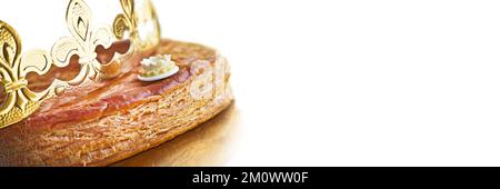 Galette des rois, französischer Königskuchen mit einer goldenen Krone auf weißem Panoramadruck Stockfoto