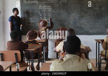 Goromonzi, Simbabwe. 7.. Dezember 2022. Ein Student schreibt am 7. Dezember 2022 an der Vhuta-Grundschule im Bezirk Goromonzi, Simbabwe, auf einem schwarzen Brett. Ein chinesisch investiertes Unternehmen hat im Rahmen seiner Initiativen zur sozialen Verantwortung der Unternehmen zwei Klassenzimmer und Möbel an eine örtliche Schule übergeben, um die lokale Bildung zu verbessern. ZU „Feature: Chinesisches Unternehmen spendet Klassenräume an die simbabwische Schule“. Guthaben: Tafara Mugwara/Xinhua/Alamy Live News Stockfoto