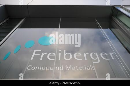 07. Dezember 2022, Sachsen, Freiberg: Das Logo der Freiberger Compound Materials GmbH hängt auf einem Fabrikgebäude. Hier werden Galliumarsenid-Wafer für Mikroelektronik und Optoelektronik hergestellt. Diese werden für Hochfrequenzkomponenten für 4G/5G-Kommunikation oder in LEDs oder Lasern verwendet. Foto: Jan Woitas/dpa Stockfoto