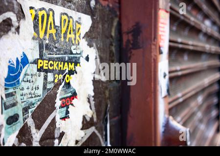 Alte Plakate an einer Wand in der Peckam High Street, London, Großbritannien Stockfoto