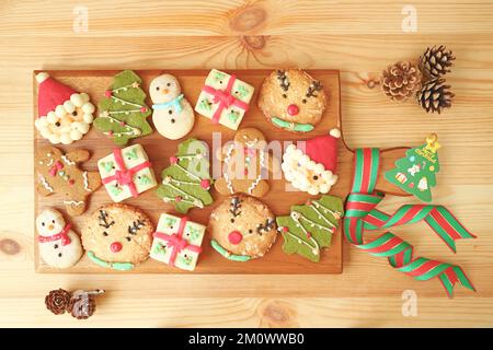 Blick von oben auf ein hölzernes Breadboard voller köstlicher Weihnachtskekse dekoriert Stockfoto