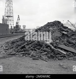 1950er Jahre, historische Stahlwerke, ein Stapel Industrieabfälle saß auf einem Stapel vor den Abbey Works in Port Talbot, South Wales, Großbritannien. Stockfoto