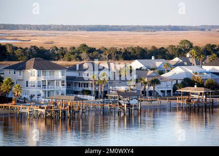 Der Sonnenuntergang über Wohnhäusern mit hölzernen Piers auf Little Marsh Island im Vorort Jacksonville (Florida). Stockfoto