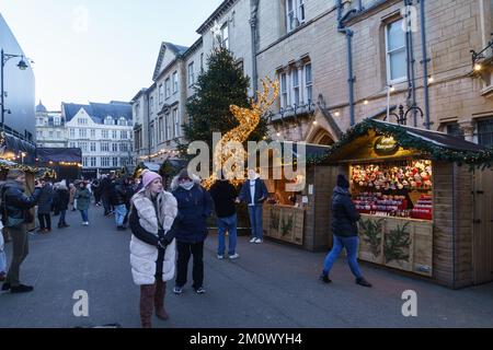 Dezember 8. 2022. Oxford, Großbritannien. Der Oxford Christmas Market kehrt in die Broad Street zurück und ist bis Dezember 18. geöffnet. Die Gegend an der Broad Street beherbergt... Verkaufsstände, an denen Markthändler ungewöhnliche und handgemachte Geschenke und farbenfrohe Dekorationen anbieten, und andere servieren Speisen und heiße Getränke. Die Geschäfte in der Umgebung öffnen bis spät in die Nacht, um den Weihnachtshandel zu sehen, der dieses Jahr eine Herausforderung sein könnte. In der Weihnachtszeit wird ein deutlicher Rückgang gegenüber den beiden Vorjahren prognostiziert, als der E-Commerce-Umsatz nach der Pandemie und Lockdowns einen starken Anstieg verzeichnete. Bridget Catterall/AlamyLiveNews Stockfoto